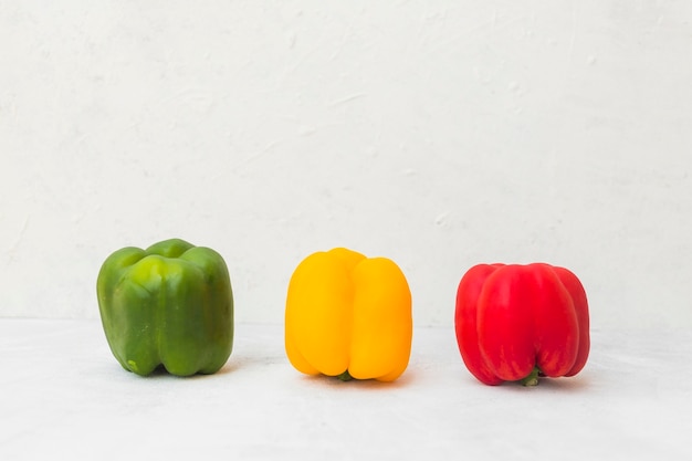 Free photo green; yellow and red bell peppers on white surface