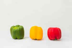 Free photo green; yellow and red bell peppers on white surface