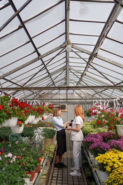 Greenhouse owner presenting flowers options to a potential customer retailer.