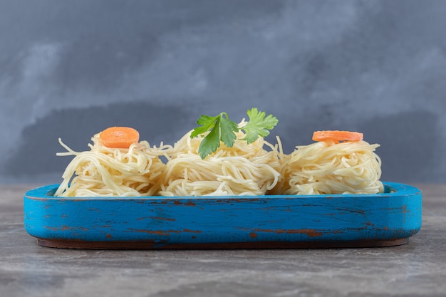 Free Photo greens and grated carrot on spaghetti, on the wooden board , on the marble.