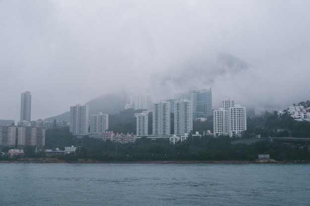 Free photo grey concrete high skyscrapers on the coast in foggy weather