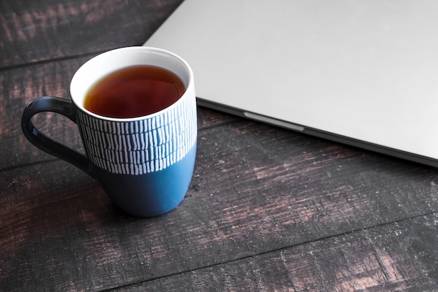 Grey laptop with coffee on wooden table