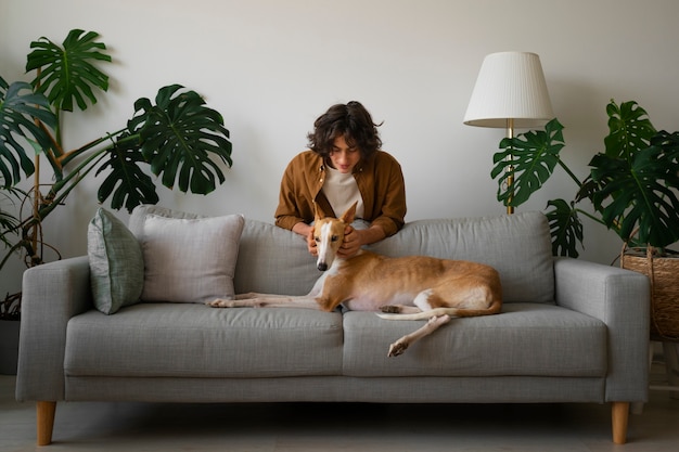 Free Photo greyhound dog with male owner at home on couch