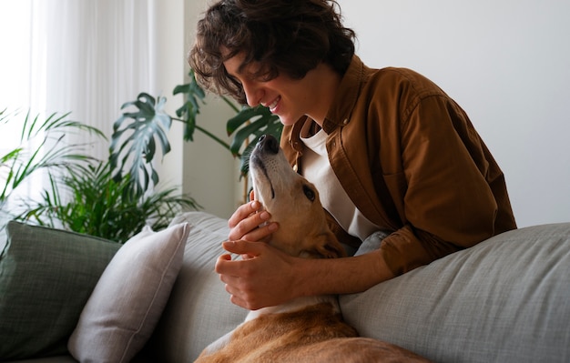 Greyhound dog with male owner at home on couch