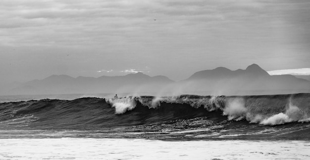 Greyscale shot of the waves of the ocean of the Copacabana Beach