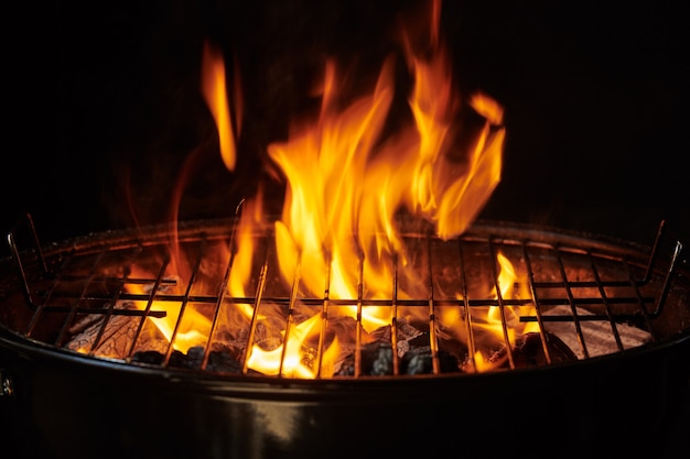 Grill Background. Barbecue Fire Grill close-up, isolated on Black Background