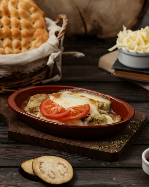 grilled aubergine topped with melted cheese in pottery pan