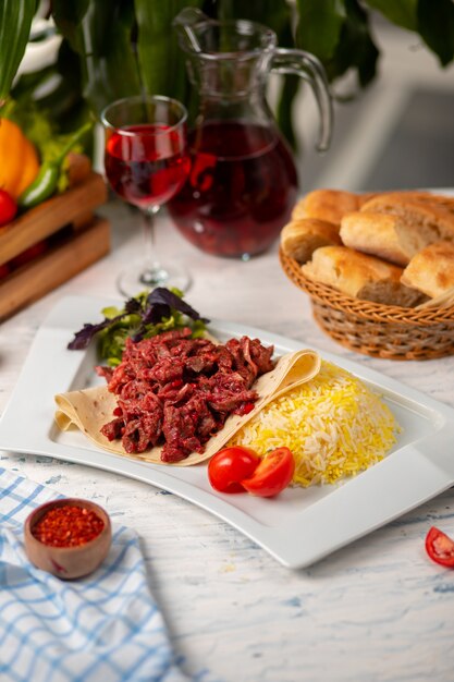 Grilled bbq beef meat slices, doner in lavash with green salad, tomatoes and rice garnish 