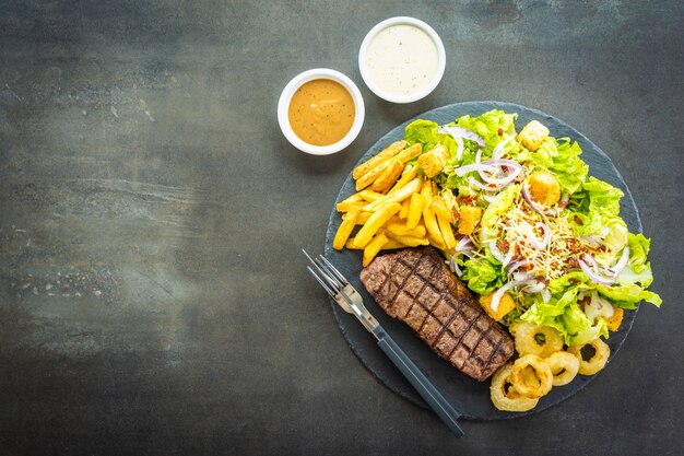 Grilled beef meat steak with french fries onion ring 