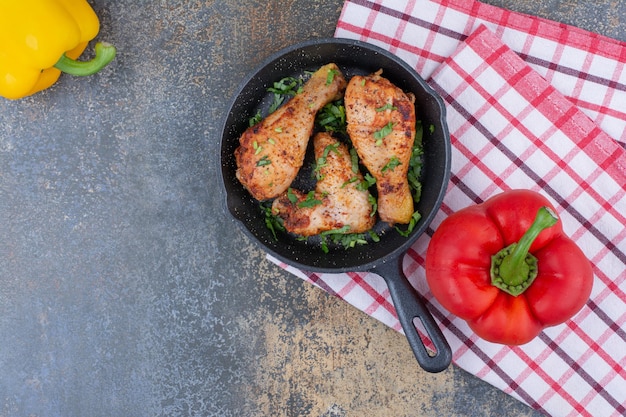 Grilled chicken drumsticks on pan with bell peppers. High quality photo