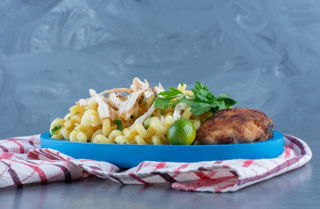 Grilled chicken and pasta on blue plate.