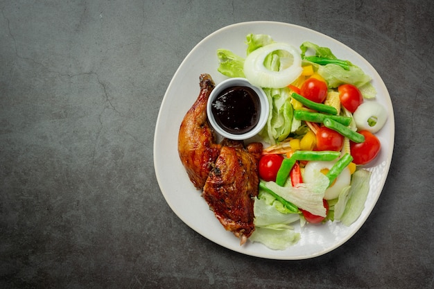 Grilled chicken steak and vegetables on dark background