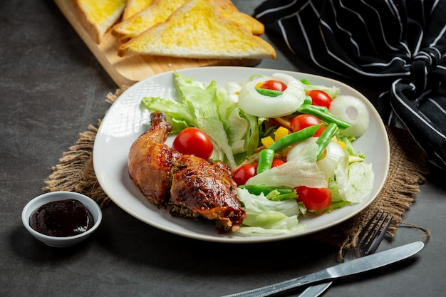 Grilled chicken steak and vegetables on dark background