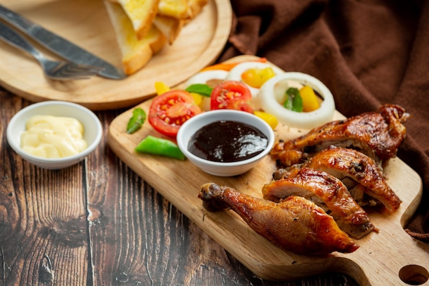 Free photo grilled chicken steak and vegetables on dark wood background