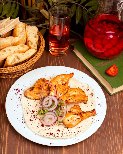 Grilled chicken wings kebab served with composto, onion vegetable salad and herbs in white plate