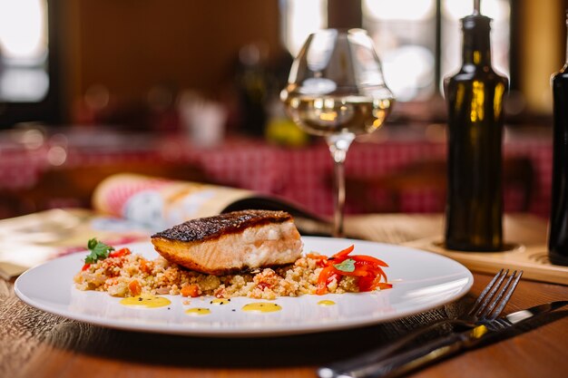 Grilled fish fillet served on top of the couscous salad with bell peppers