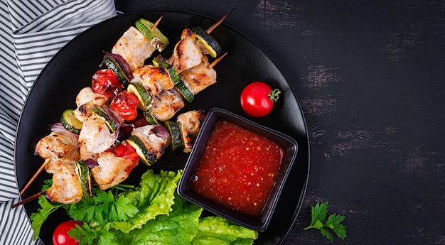 Free Photo grilled meat skewers, chicken shish kebab with zucchini, tomatoes and red onions