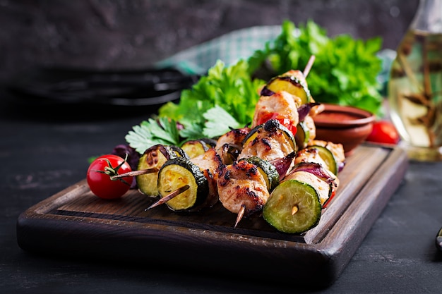 Grilled meat skewers, chicken shish kebab with zucchini, tomatoes and red onions