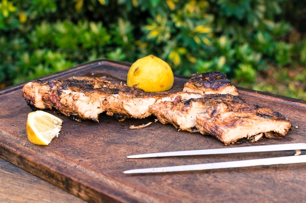 Grilled meat and sliced ​​lemon on table