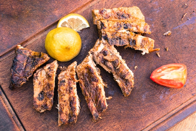 Grilled meat and sliced ​​lemon tomato  on table