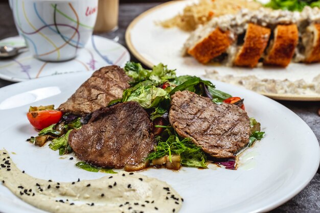 Grilled meat with lettuce mushrooms tomato hummus sids view