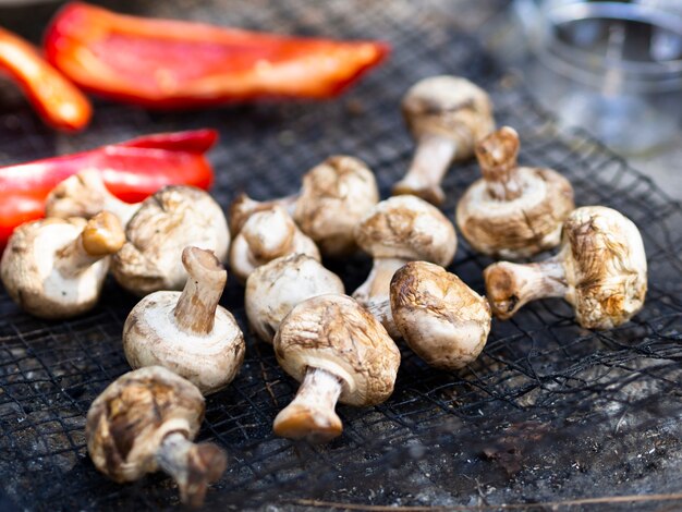 Grilled mushrooms and sliced bell pepper on grid