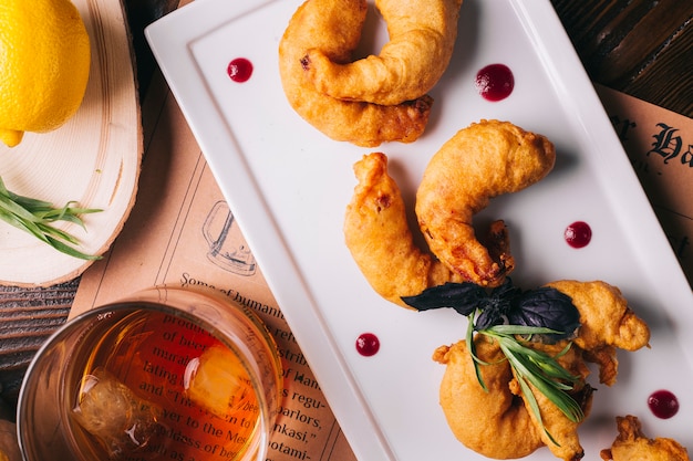 Free photo grilled pawns in white plate with red basilic and rosemary leaves.