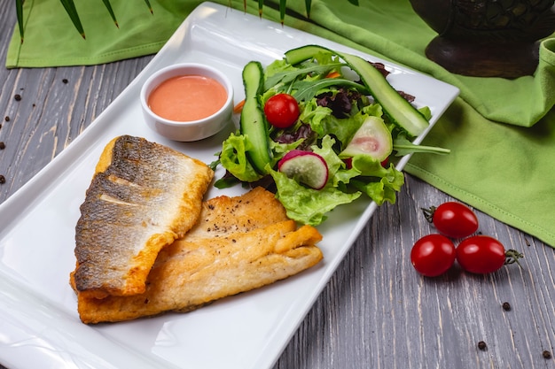 Free Photo grilled trout fish tomato cucumber lettuce radish side view