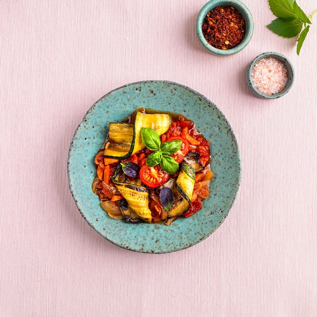 Free photo grilled zucchini with vegetables in tomato sauce the concept of vegetarian food