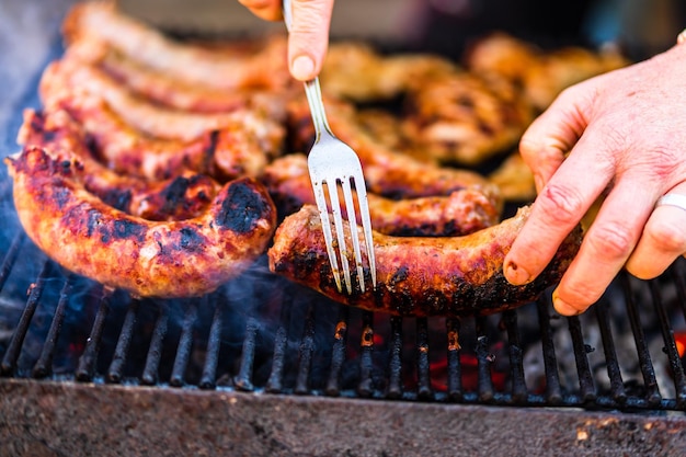 Grilling sausages and pork chops on barbecue grill. BBQ in the g