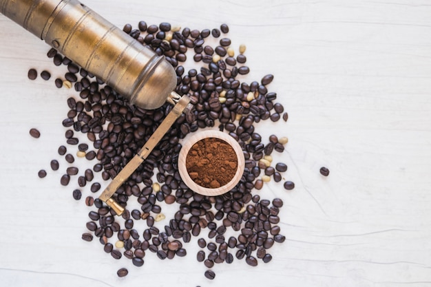 Grinder and ground coffee on coffee beans