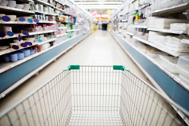 Free photo grocery shopping cart in supermarket aisle