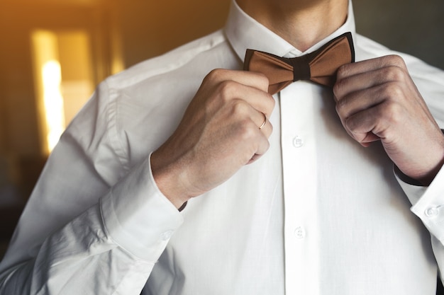 Free photo groom adjusting bow tie