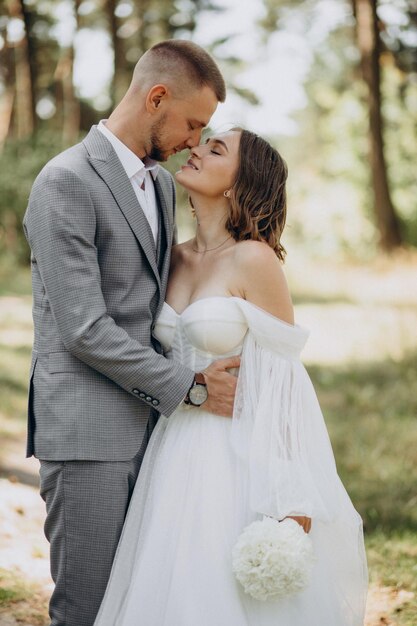 Groom and bride on their wedding day in forest