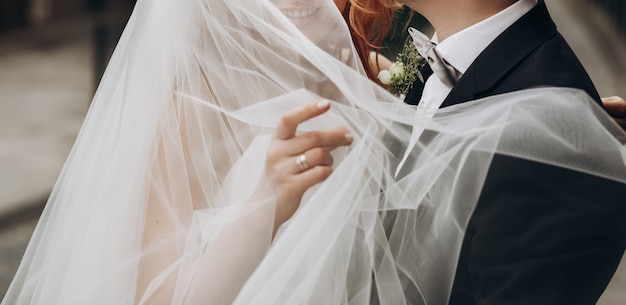 Groom carries charming bride on his arms