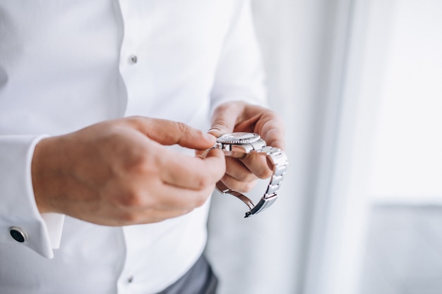 Free photo groom checking time on his wrist watch