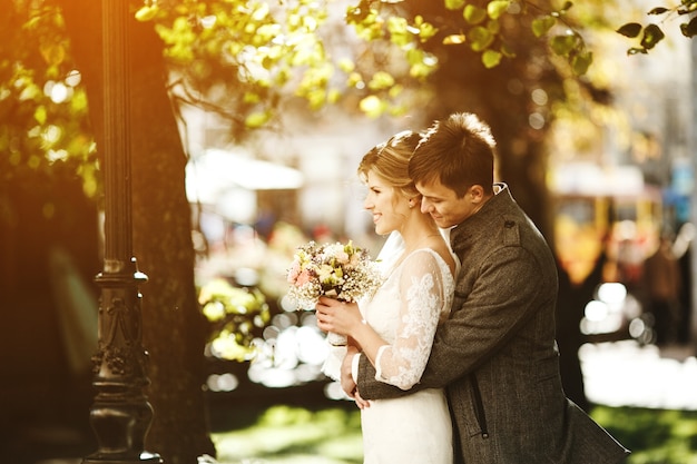 Groom embracing the bride on a sunny day