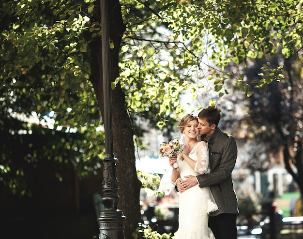 Groom embracing from behind his girlfriend with the dress