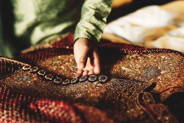 Groom in green shirt touches his red sherwani 