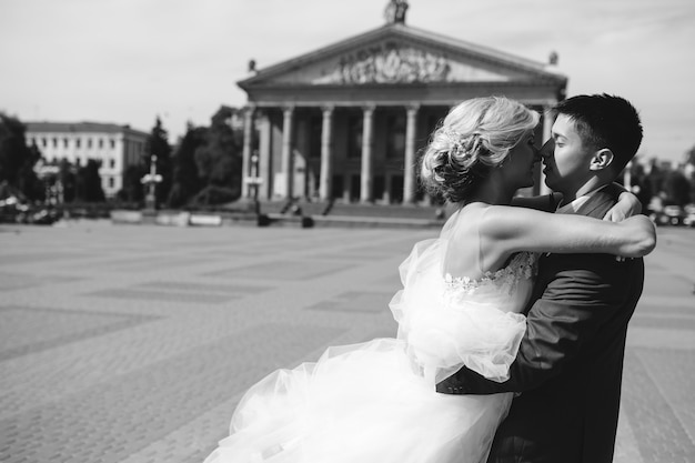 Free Photo groom holds bride in his arms and twisted