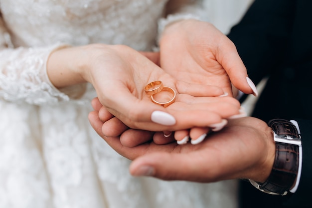 Free photo groom holds bride's hands, where are two wedding rings