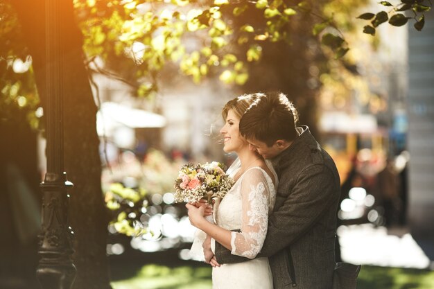 Groom hugging the bride and kissing her neck