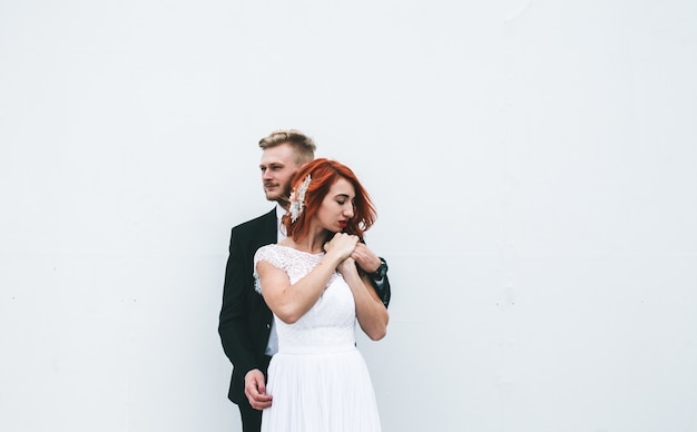 Free Photo groom hugging his bride with white background