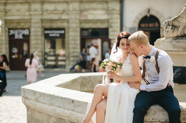 Free Photo groom kisses on the shoulder in a fountain