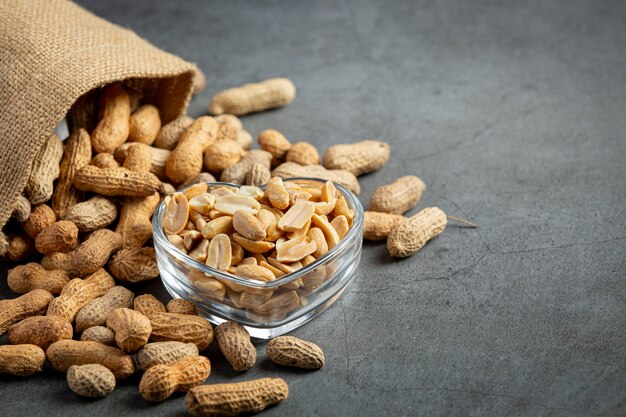 Groundnuts in heart shape plate put next to a sack of groundnuts