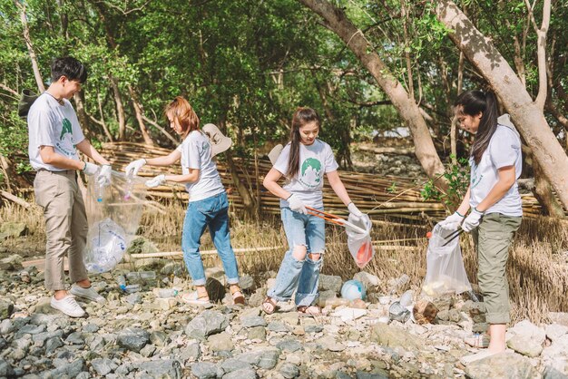 Group of asian diverse people volunteer teamwork environment conservationvolunteer help to picking plastic and foam garbage on park areaVolunteering world environment day