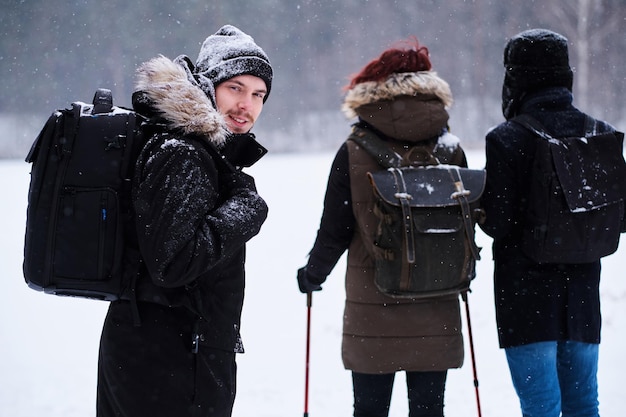 Free photo group of backpackers hike in the cold snowy forest