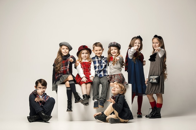 The group of beautiful girls and boys on a pastel wall