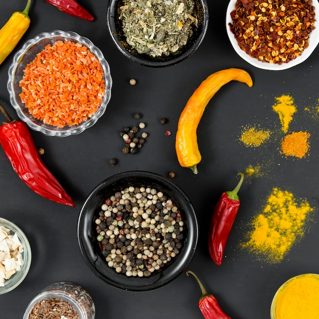 Free photo group of bowls full of spices on black background