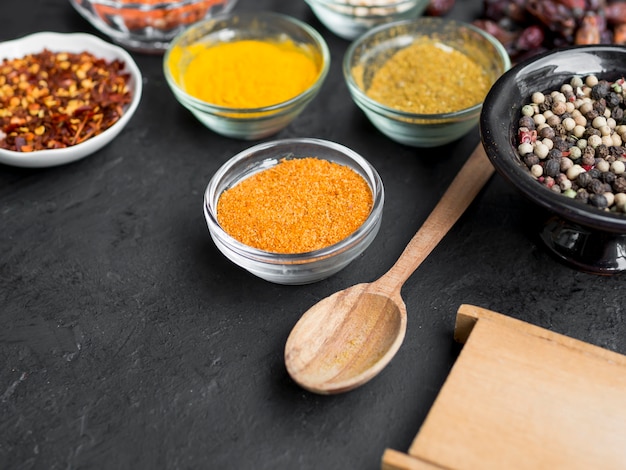 Free Photo group of bowls full of spices on black background